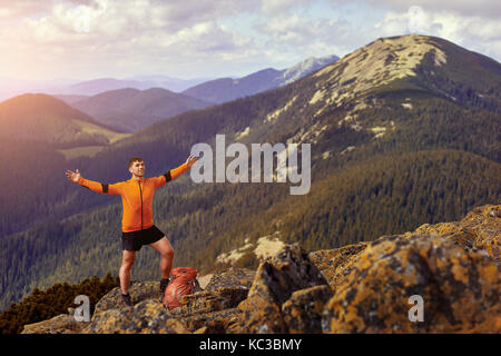 Happy hiker winning reaching life goal, success, freedom and happiness, achievement in mountains. Stock Photo