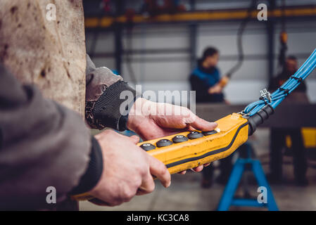Overhead Crane Operator in big industrial hall Stock Photo