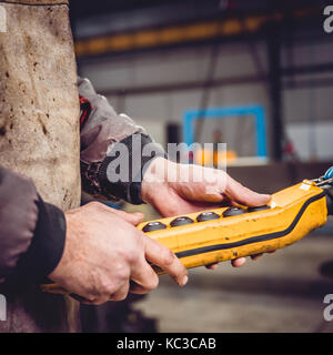 Overhead Crane Operator in big industrial hall Stock Photo