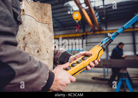 Overhead Crane Operator in big industrial hall Stock Photo