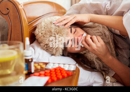 Sick young woman on the bed in the room Stock Photo