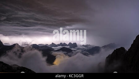 The Dolomites, Northern Italy. Electrical storm at night seen over the cloud filled Val di Zoldo from the Rifugio Coldai mountain guesthouse (2132m) Stock Photo
