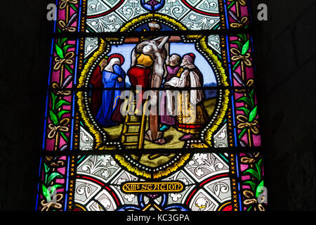 Stained glass window depicting the 13th station of the cross - Jesus being removed from the cross - church at Les Andelys, Normandy, France Stock Photo