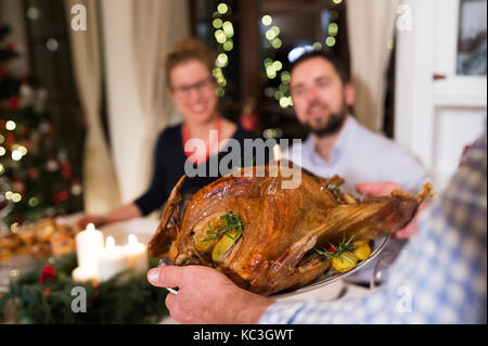 Family celebrating Christmas. Roasted turkey on tray. Stock Photo