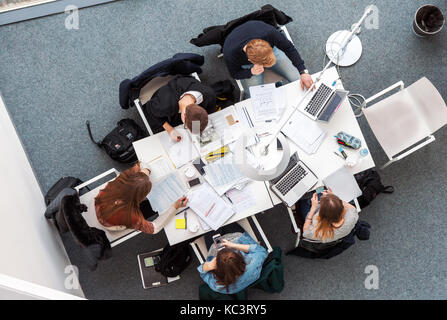 Overhead high angle picture of young male students sitting and studying in coworking space in Vilnius University li Stock Photo