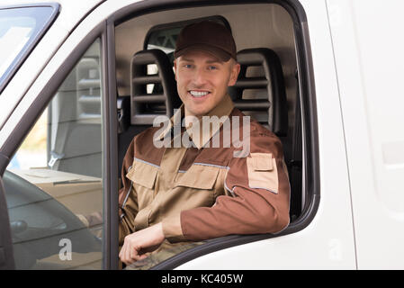 Portrait of confident delivery man smiling in truck Stock Photo