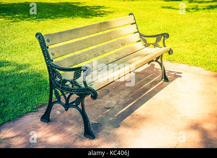 Old styled wooden park bench in a city park Stock Photo