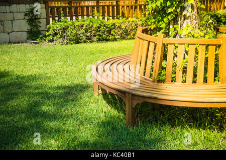 Old styled wooden park bench in a city park Stock Photo