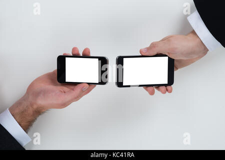 Cropped image of businessmen using mobile phones at table Stock Photo