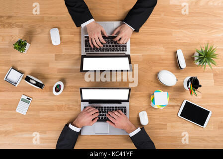 Directly above shot of businessmen using laptops at desk in office Stock Photo