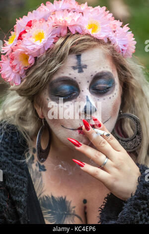 Young woman in a mask, Day of the Dead, Dia de Los Muertos, woman smoking a cigarette, Prague, Czech Republic woman wreath Stock Photo