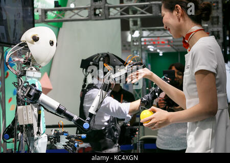 Chba, Japan. 3rd Oct, 2017. A booth assistant interacts with a master-slave robot TELESAR V while a man is controlling it using virtual reality technology at CEATEC Japan 2017 on October 3, 2017, Chiba, Japan. The Combined Exhibition of Advanced Technologies (CEATEC) Japan is a technology exhibition showing the latest trends and developments. Credit: Aflo Co. Ltd./Ģ����ý Live News Stock Photo