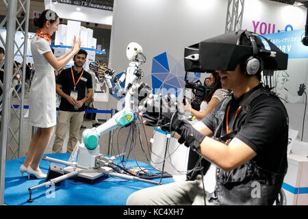 Chba, Japan. 3rd Oct, 2017. A booth assistant interacts with a master-slave robot TELESAR V while a man is controlling it using virtual reality technology at CEATEC Japan 2017 on October 3, 2017, Chiba, Japan. The Combined Exhibition of Advanced Technologies (CEATEC) Japan is a technology exhibition showing the latest trends and developments. Credit: Aflo Co. Ltd./Ģ����ý Live News Stock Photo