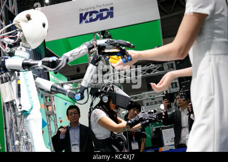 Chba, Japan. 3rd Oct, 2017. A booth assistant interacts with a master-slave robot TELESAR V while a man is controlling it using virtual reality technology at CEATEC Japan 2017 on October 3, 2017, Chiba, Japan. The Combined Exhibition of Advanced Technologies (CEATEC) Japan is a technology exhibition showing the latest trends and developments. Credit: Aflo Co. Ltd./Ģ����ý Live News Stock Photo