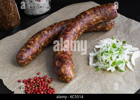 Two raw sausages with onion and spices Stock Photo