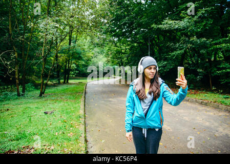 young pretty woman was interrupted video call while run in the park young autumn day Stock Photo