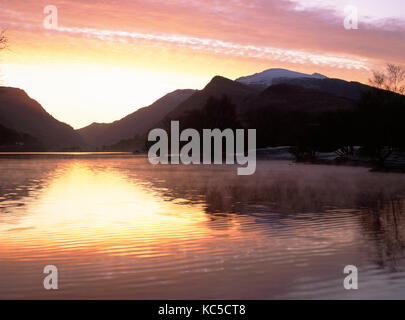 Looking east over Llyn Padarn lake towards LLanberis pass and Snowdon. From Lagoons created out of old slate tips/waste. Midwinter sunrise Stock Photo