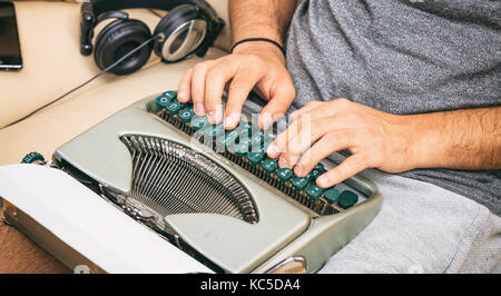 Man typing on a vintage typewriter. Close up on hands Stock Photo