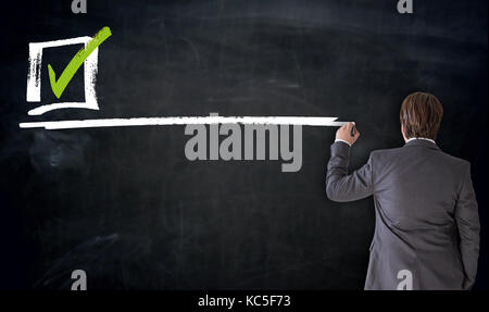 Businessman writing checkbox on blackboard concept. Stock Photo