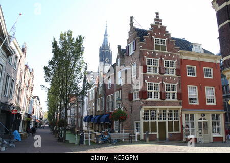 Picturesque inner city of Delft, Netherlands at Voldersgracht. Nieuwe Kerk  in the background. On corner 16th century gabled house De Kaerskorf. Stock Photo