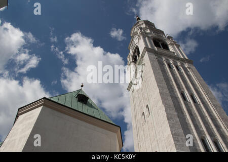 The view of blue sky with clouds behind white belfry church of Cortina d'Ampezzo, Dolomites, Veneto, Italy. Stock Photo