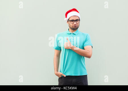 Successful bearded man showing thumb up and looking at camera. Isolated studio shot on gray background Stock Photo