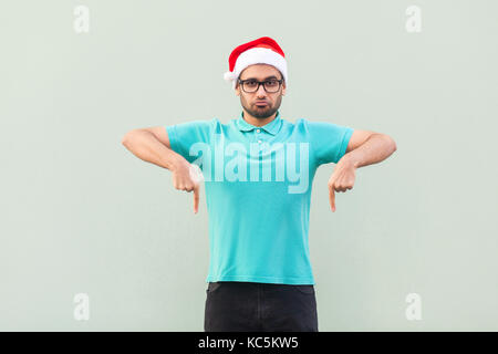 Just now, best price for you! Look this! Handsome bearded man pointong fingers down and looking at camera. Christmas sale and black friday. Studio sho Stock Photo