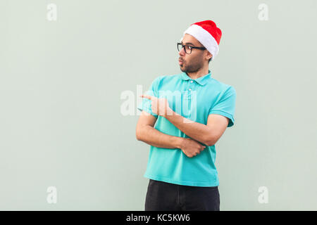 Wow! Handsome  man with beard in shoked. Pointing away while standing isolated on gray background. Studio shot Stock Photo
