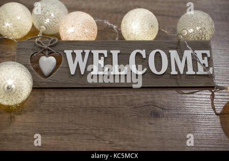 Decorative text welcome with multicolour lights on the wooden table Stock Photo