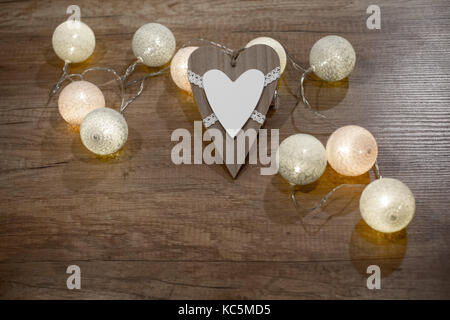 Decorative handmade heart with multicolour lights on the wooden table Stock Photo