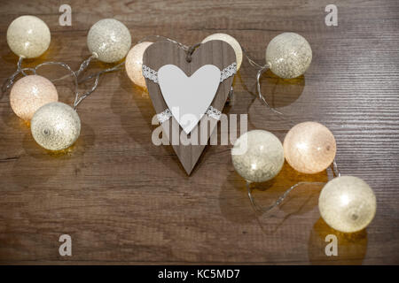 Decorative handmade heart with multicolour lights on the wooden table Stock Photo