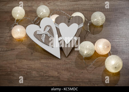 Decorative handmade hearts, with multicolour lights on the wooden table Stock Photo