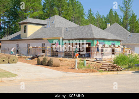 Brick layers working on a new home under construction need to use scaffolding to reach the upper parts of the exterior walls. Pike Road Alabama, USA. Stock Photo