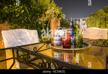 Moroccan tea party set up in a warm oriental candlelights atmosphere at night. Chefchauen, Morocco Stock Photo