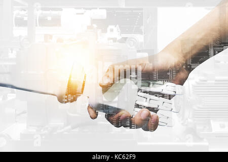 Artificial intelligence and robotic concepts. Industrial 4.0 Cyber Physical Systems concept. Double exposure of Robot and Engineer human holding hand  Stock Photo