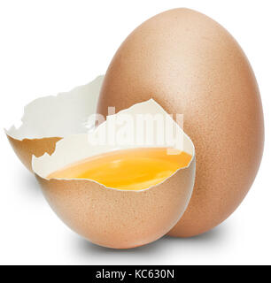 Closeup of one (intact) and half eggs with the cracked brown shell revealing yellow yolk and egg white, white background. Stock Photo