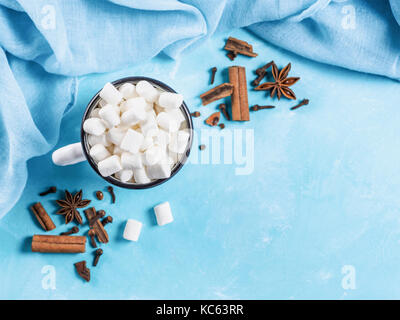 Marshmallows and winter spices on blue background Stock Photo