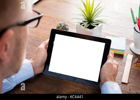 Close-up Of A Person Using Digital Tablet On Wooden Desk Stock Photo