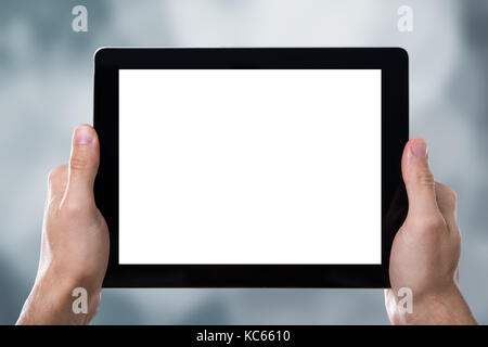 Close-up Of Hands Holding Digital Tablet With A Blank Screen Stock Photo