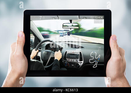 Close-up Of A Person Playing Car Racing Game On Digital Tablet Stock Photo