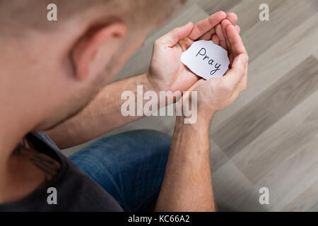 Man Holding Piece Of Paper With The Text Pray In His Hand Stock Photo