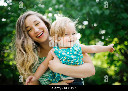 Portrait of mother carrying daughter (12-17 months) Stock Photo