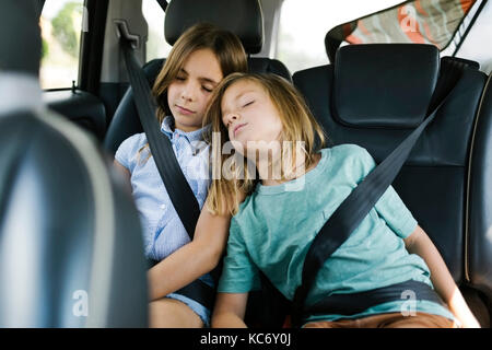Brother (6-7) and sister ( 8-9) sleeping in car Stock Photo