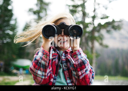 Portrait of boy (6-7) looking through binoculars Stock Photo