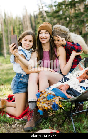 Mother with son (6-7) and daughter (8-9) camping in forest Stock Photo