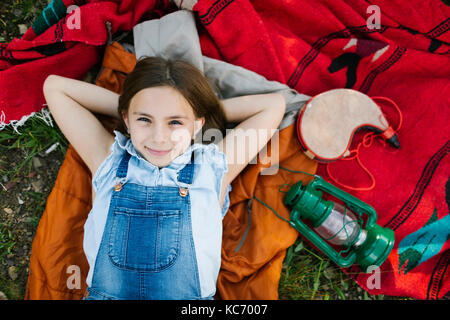 Portrait of girl (8-9) lying on blanket Stock Photo