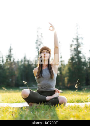 Woman practicing yoga in forest Stock Photo