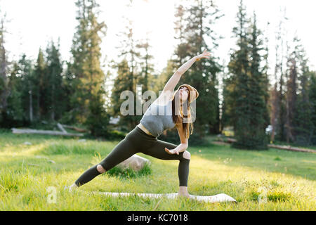 Woman practicing yoga in forest Stock Photo