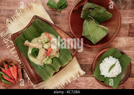 Ayam Garang Asam. Javanese steamed chicken with coconut milk, spices, and bilimbi in banana leaf parcels. Stock Photo