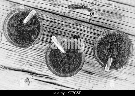 black and white photo. spinach detox. Glass of spinach juice on wooden background Stock Photo